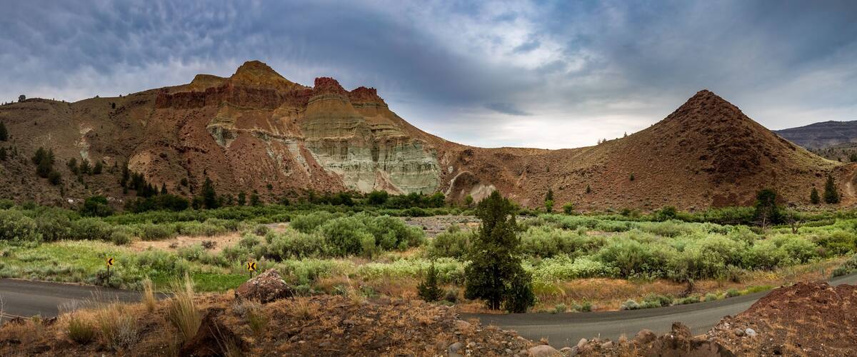 A road winding through a rugged landscape with prominent rock formations and sparse vegetation.