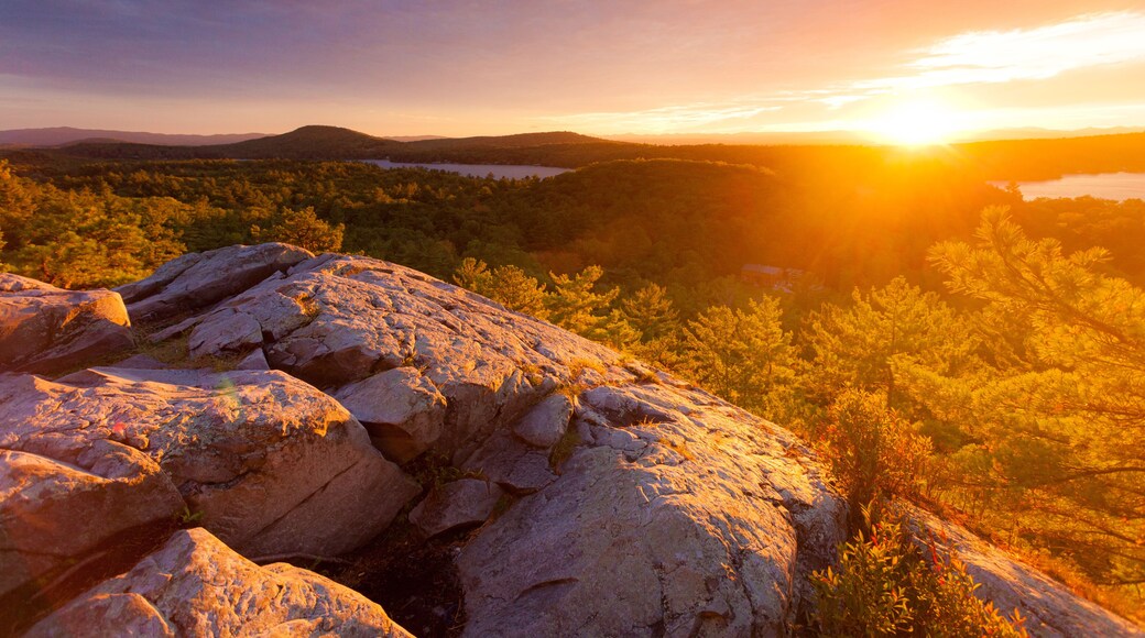 Rocky mountaintop overlooking Lake Dunmore and forest at sunset during autumn
