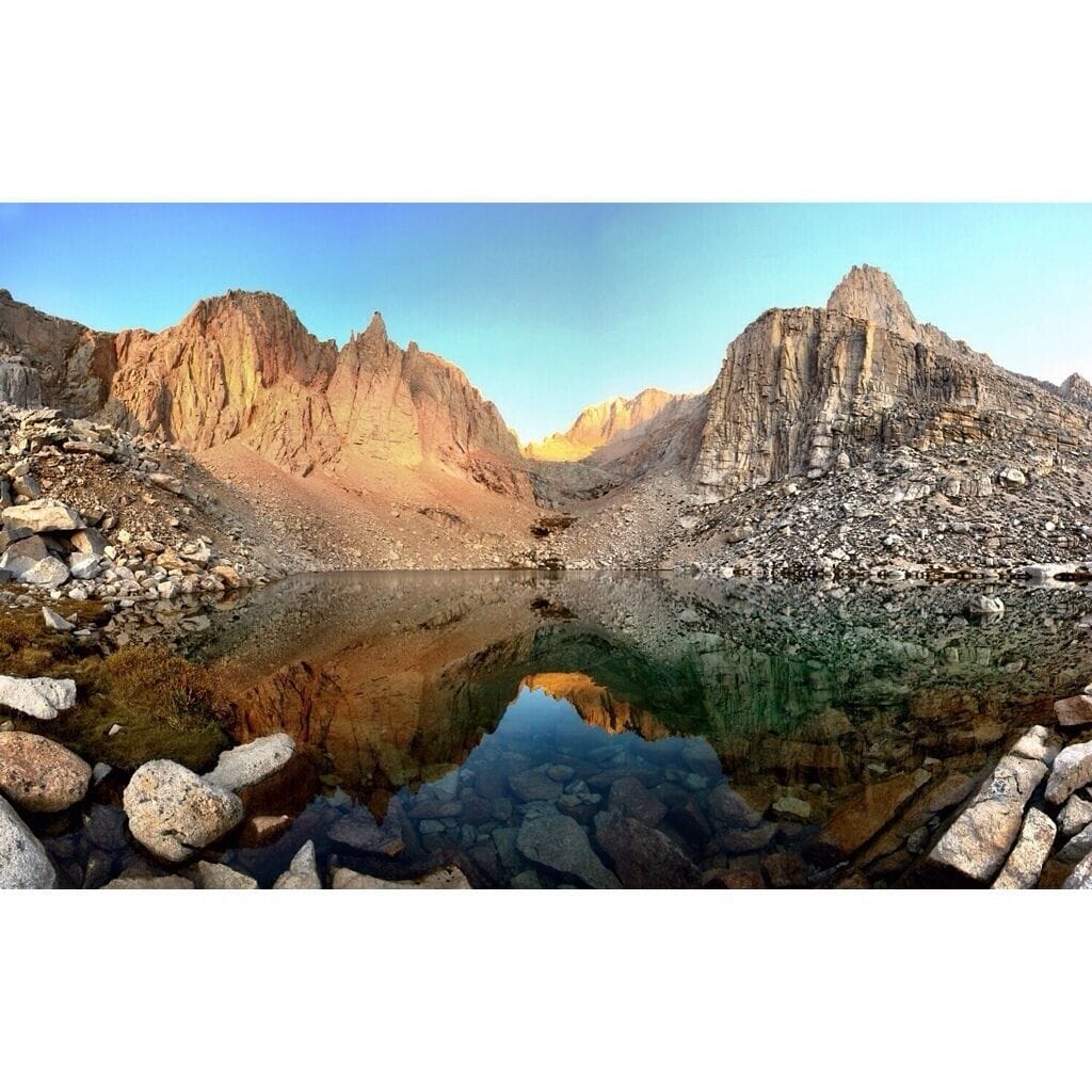 A mountain lake with rocky terrain and steep cliffs.