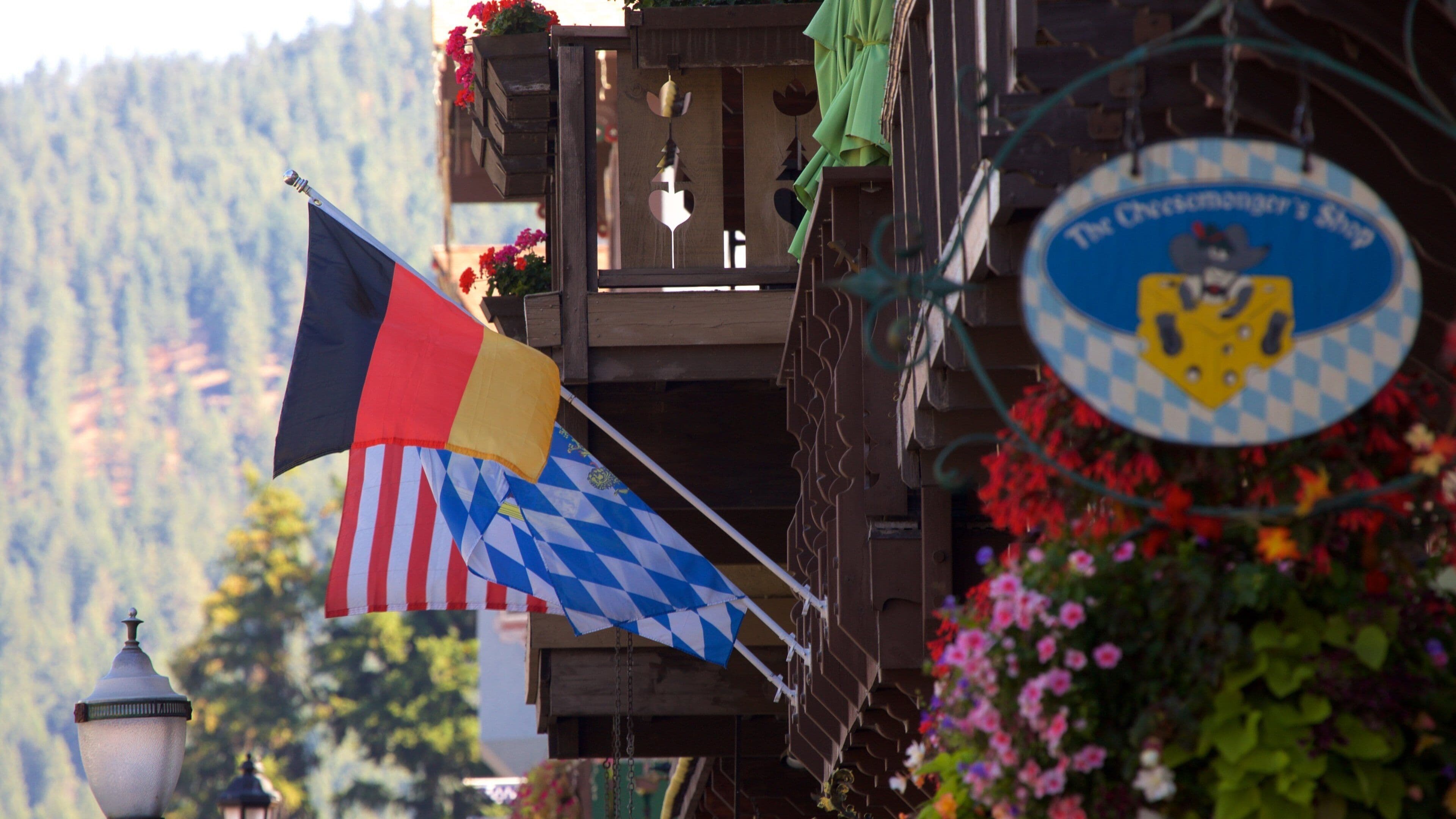 A building with flags, a sign, and flowers.