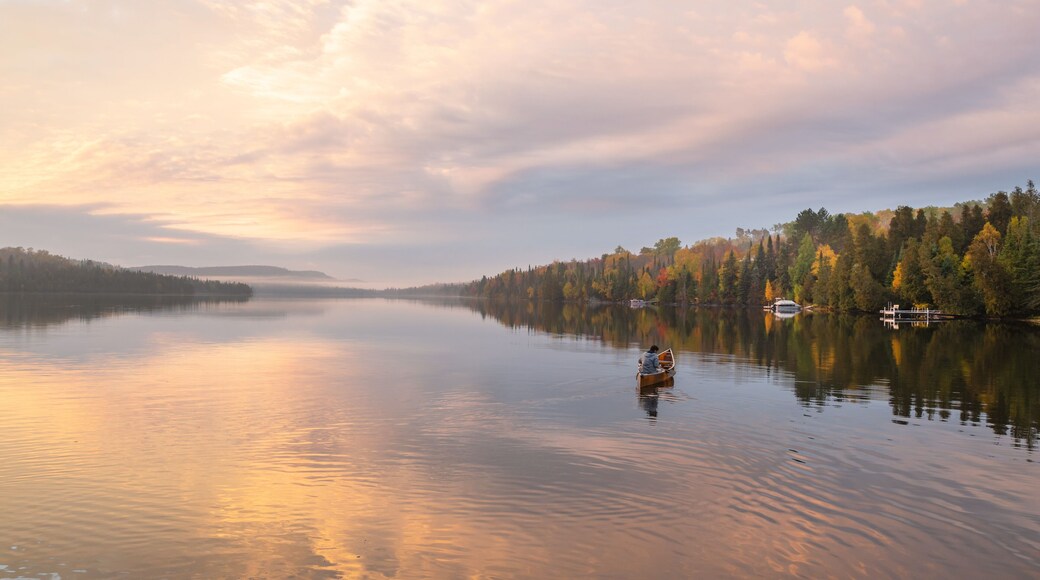 People are boating on Caribou Lake on a fogy morning