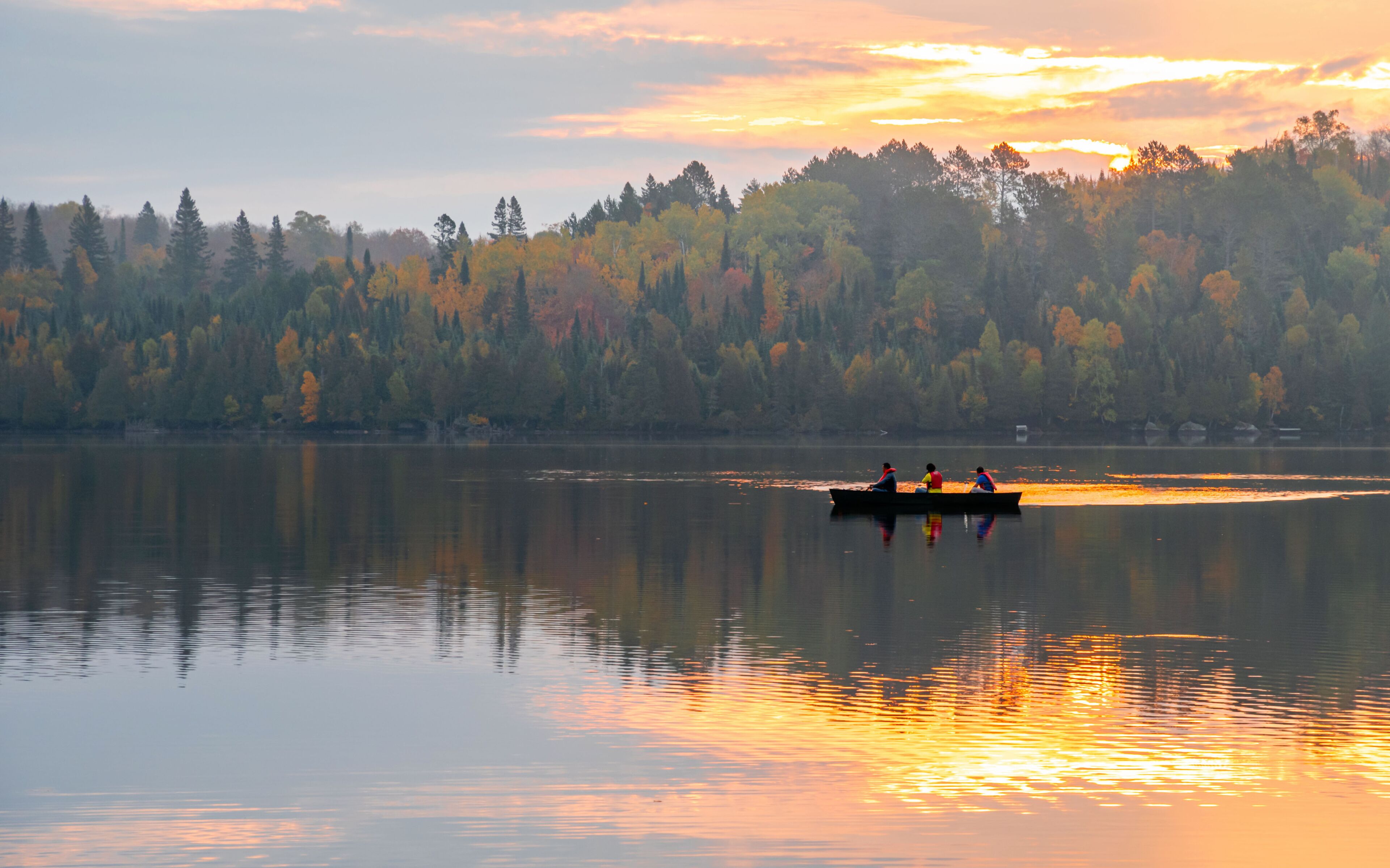 People are boating on Caribou Lake on a fogy morning	
