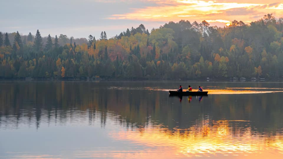 People are boating on Caribou Lake on a fogy morning
