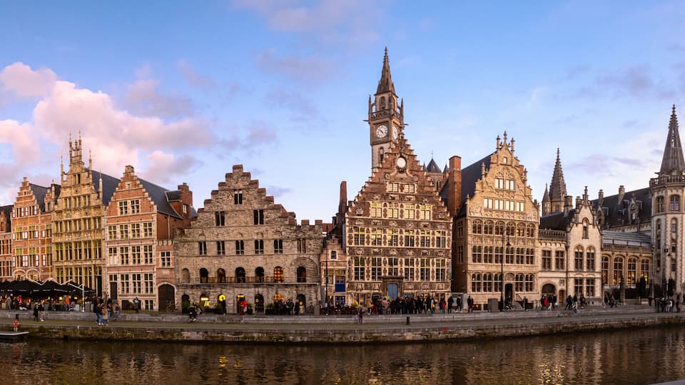 A historic European city with a prominent building featuring a clock tower and intricate architecture.