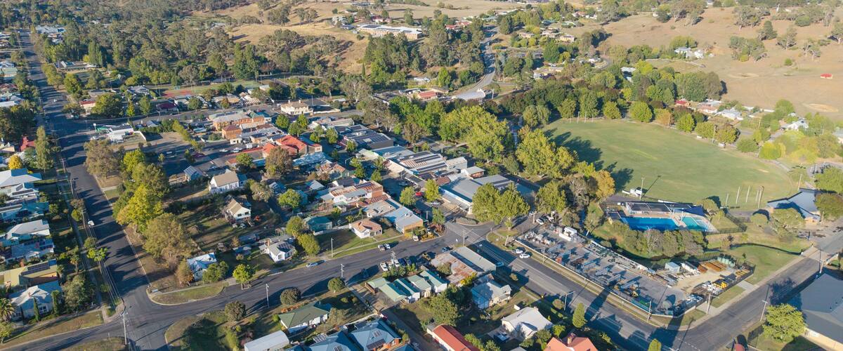 An aerial view of a residential area with houses, roads, and green spaces.
