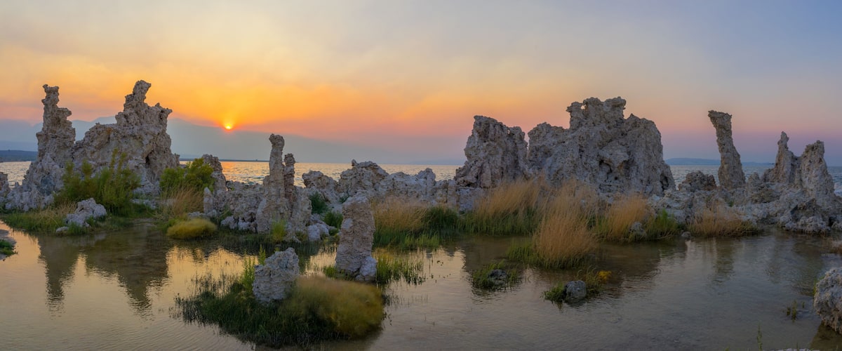 A coastal landscape with unique rock formations and a sunset.