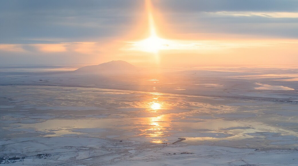 Panoramic aerial view of sunset. Arctic landscape. The northern city of Anadyr is located on the banks of the Anadyr estuary, surrounded by snow-covered tundra. Cold autumn in Chukotka Region. Russia.