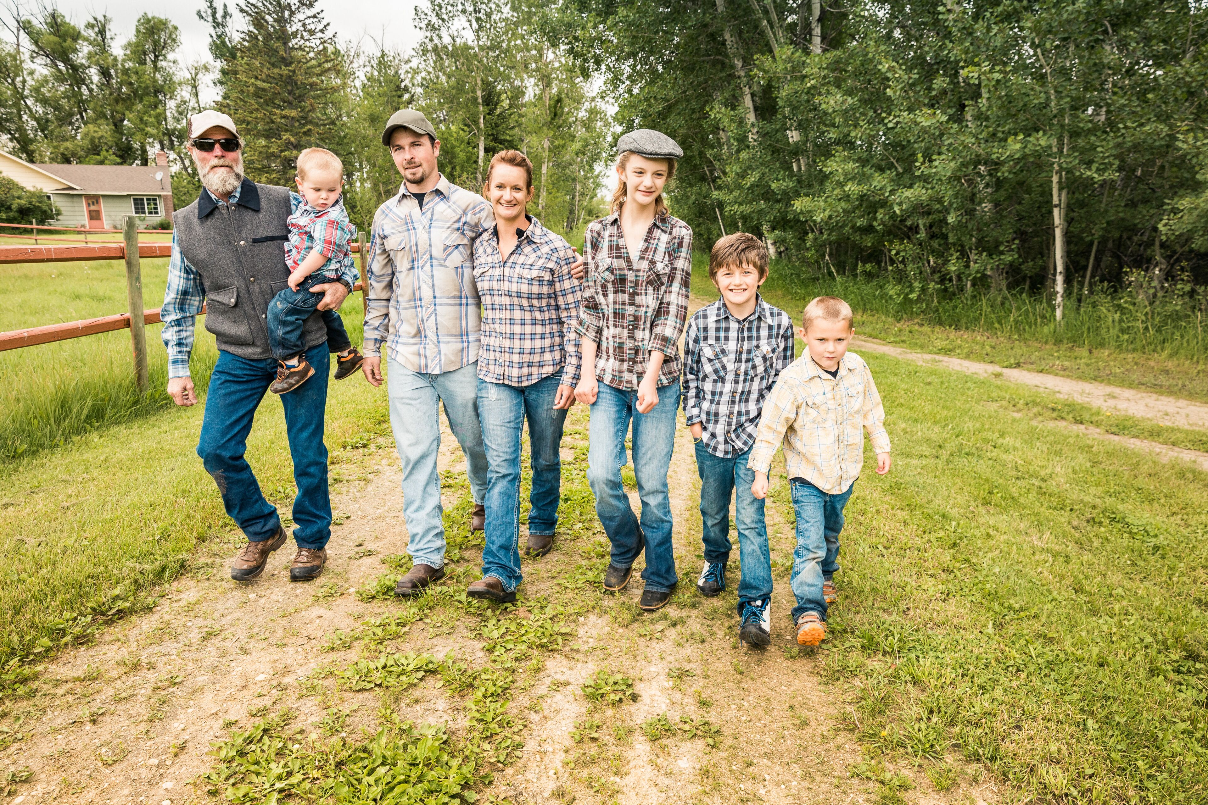 Western family walking together down driveway. Red Lodge, Montana, USA