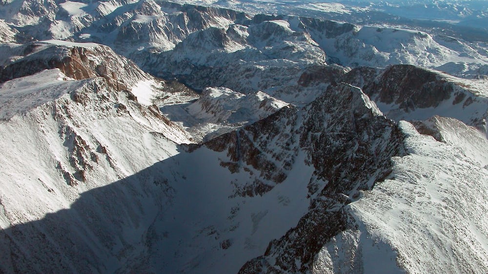 Ein verschneites Gebirge mit zerklüfteten Gipfeln und Tälern.