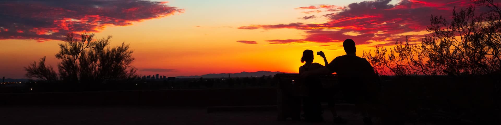 Colorful sky after the sun went down, couple enjoying the scenic nature, taking pictures