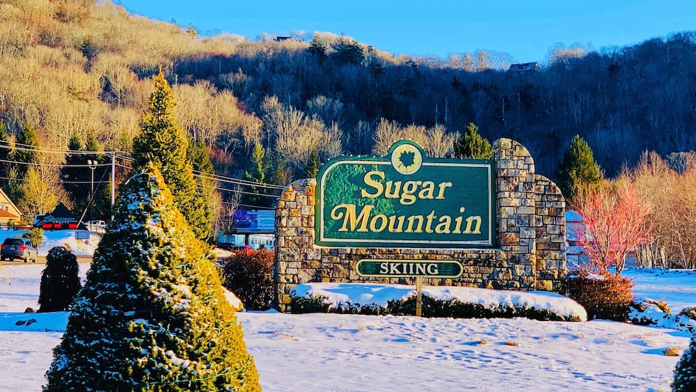 A sign for Sugar Mountain with a skiing label.