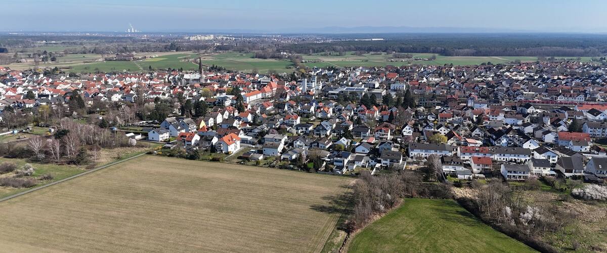 A densely populated town with a mix of residential buildings and open fields.