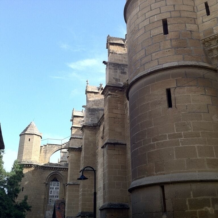 A historic stone building with a round tower and arched windows.
