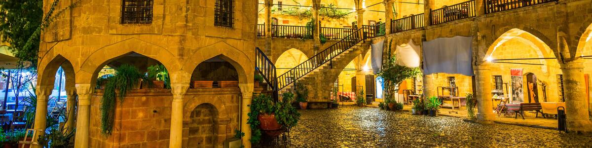 A historic courtyard with a dome, arches, and a cobblestone floor.