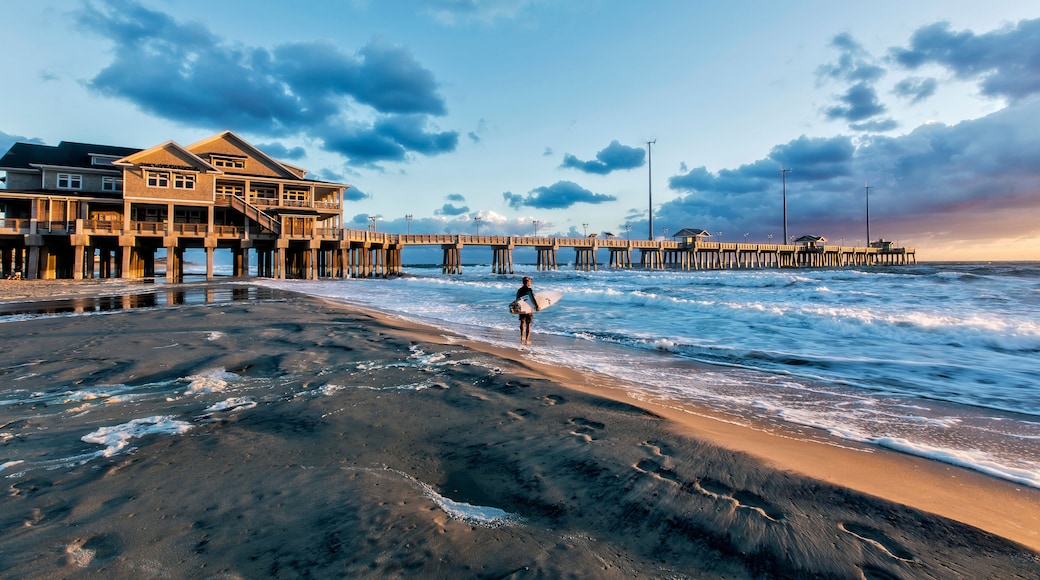 A surfer studying the waves just after sunise at Jeannette's Pier, Nags Head, N.C.