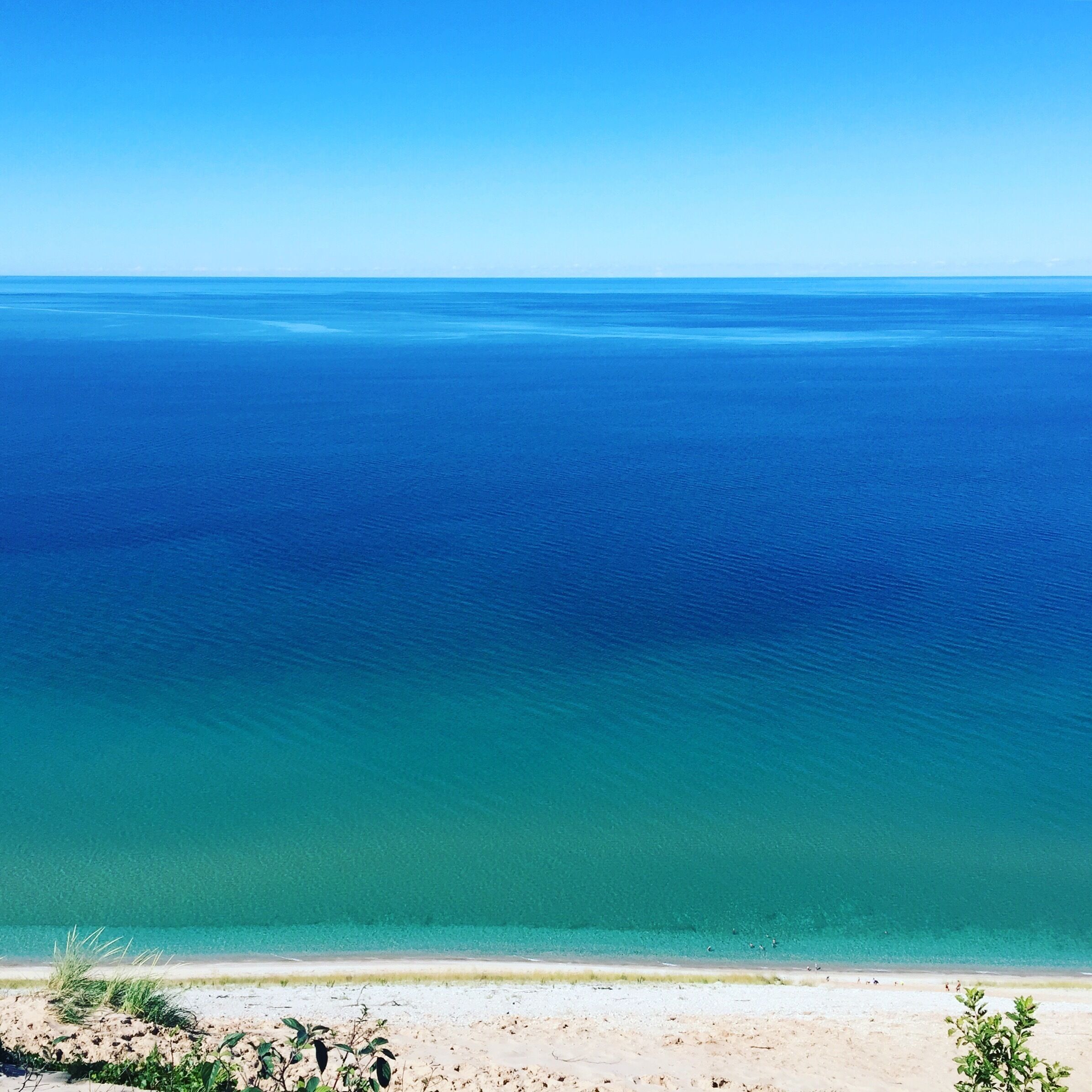 A beach with clear turquoise water and a sandy shore.