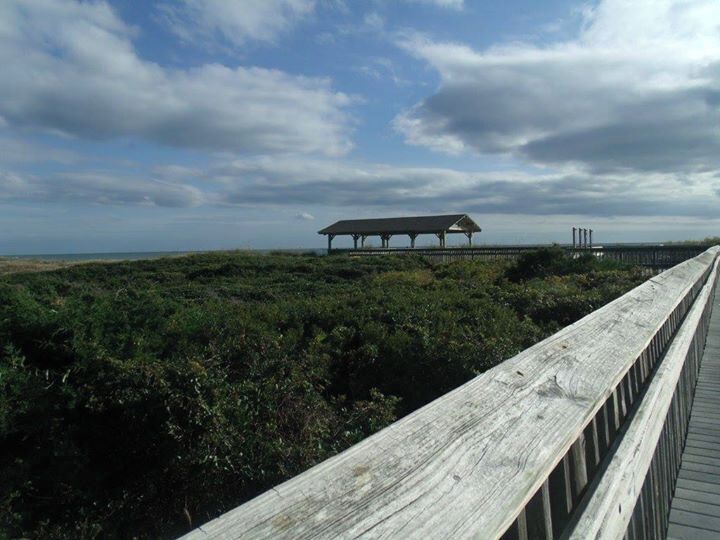 Board walk and beach pavilion over the sand dunes to the beach.