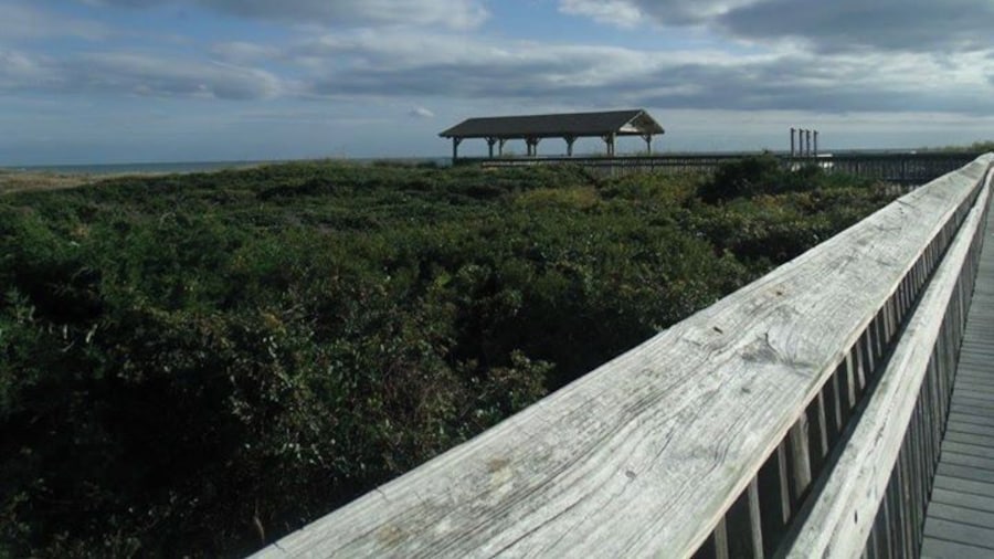 Board walk and beach pavilion over the sand dunes to the beach.