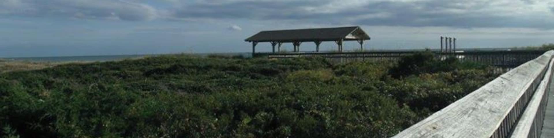 Board walk and beach pavilion over the sand dunes to the beach.
