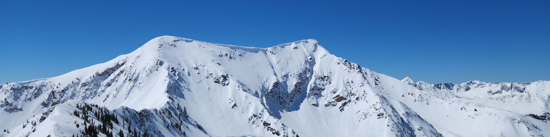 Una montaña nevada con un cielo azul despejado.