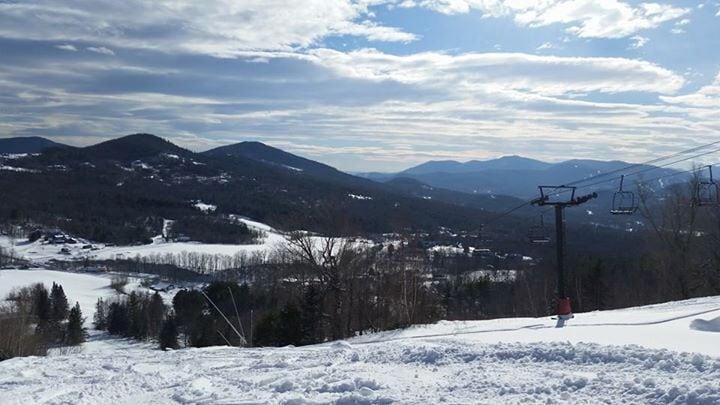 A snowy mountain landscape with ski lifts and a ski slope.