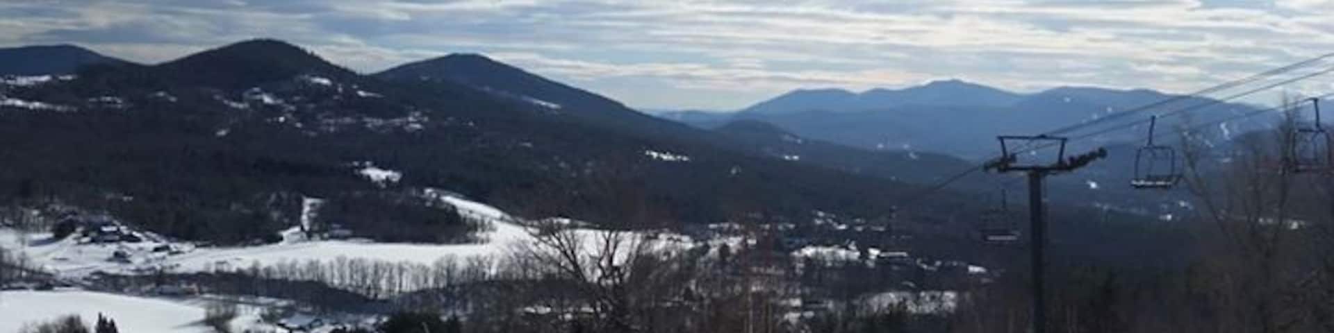 A snowy mountain landscape with ski lifts and a ski slope.