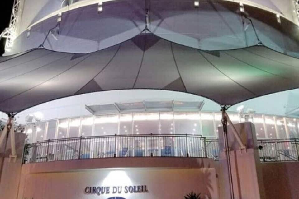 A modern building with a large, white, curved roof and a sign that reads "CIRQUE DU SOLEIL".