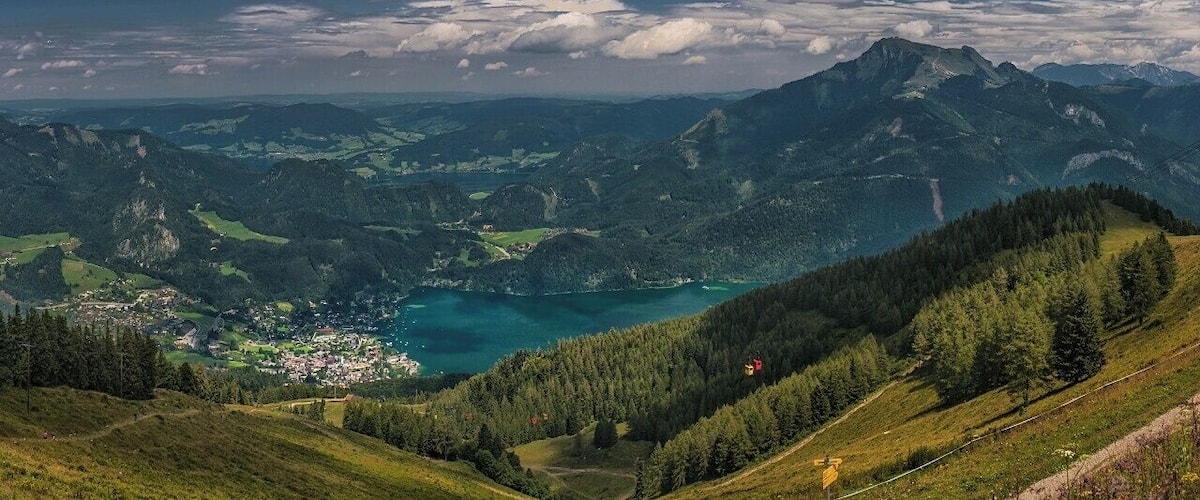 August 2010
View of Wolfgangsee from Zwolferhorn
This panoramic view from Zwolferhorn cable lift top station towards the lake Wolfgangsee. Zwolferhorn has elevation of 1.521 meters and the lift goes from the village of Sankt Gilgen (522 m), left in the picture. On the right side you can see the mighty Schafberg (alt. 1.728 m), which is another popular hiking spot in this area.