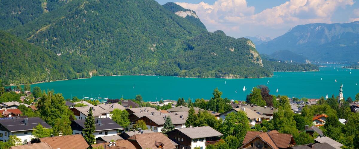 A lake surrounded by mountains and houses.