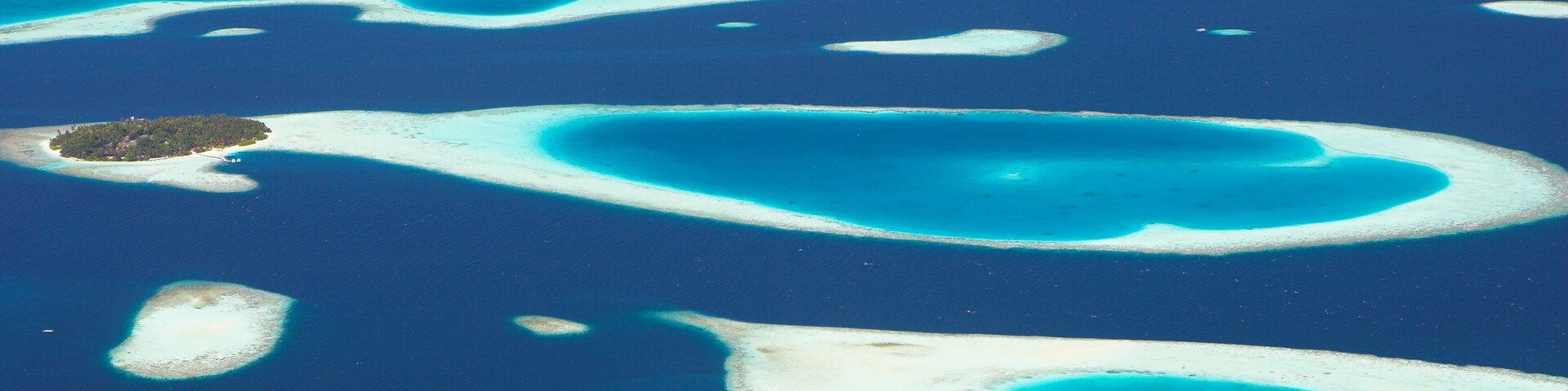 Um conjunto de atóis turquesa com praias de areia branca e águas azul-claras.