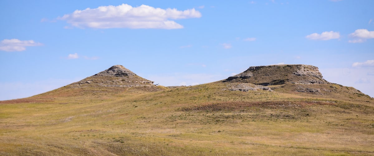 A grassy hill with two prominent mounds.