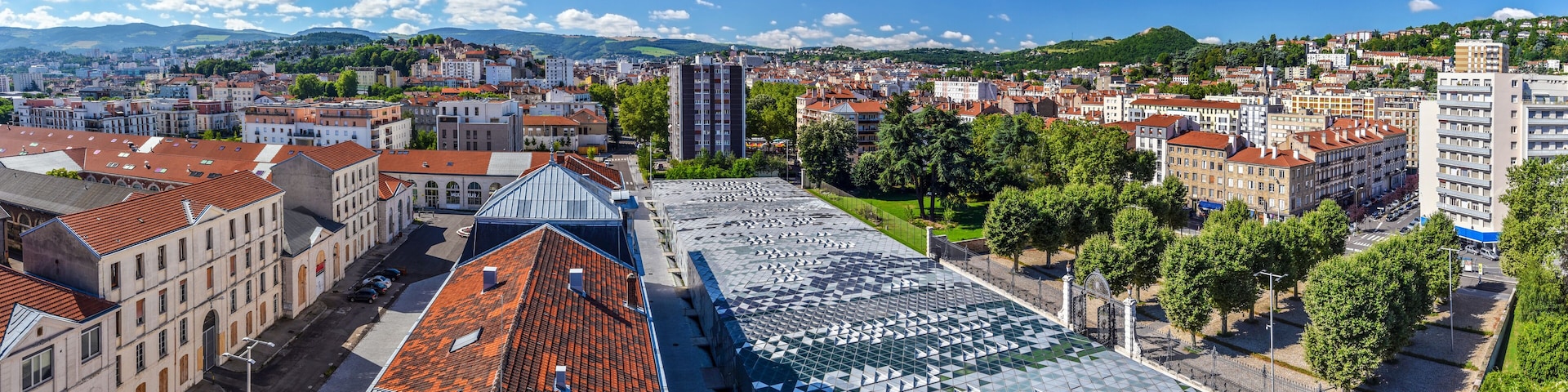 Panoramic view of Saint Etienne cityscape as seen from the tower of Cite du Design in downtown direction. Buildings of Higher School of Art and Design are at foreground. The Montaud hill is at right.