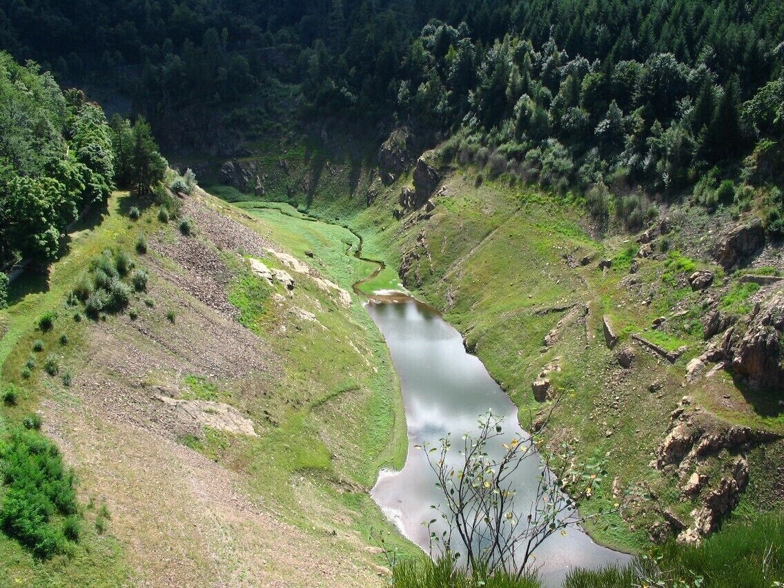 Retenue du Gouffre d'Enfer au S-E de Saint-Etienne, Loire, alt. 787 m, presque à sec en cette fin d'été 2008. A sa mise en eau en 1866, le barrage de 52 m est le plus haut d'Europe. Barrant le cours du Furan à 7 km du centre ville entre les villages de Planfoy et Rochetaillée, il est bâti afin de fournir de l'eau potable à la jeune agglomération en pleine croissance, connaissant un fort essor industriel. Rempli, sa capacité nominale est de 1,3 Mm3. Depuis le milieu de décennie 1980 l'ouvrage sert surtout d'écrêteur (retardateur) de crue, c'est pourquoi le réservoir est quasiment vide en permanence, la fonction d'approvisionnement en eau étant dévolue au Pas du Riot, situé 2 km en amont et réalisé en 1878, à 855 m d'altitude.