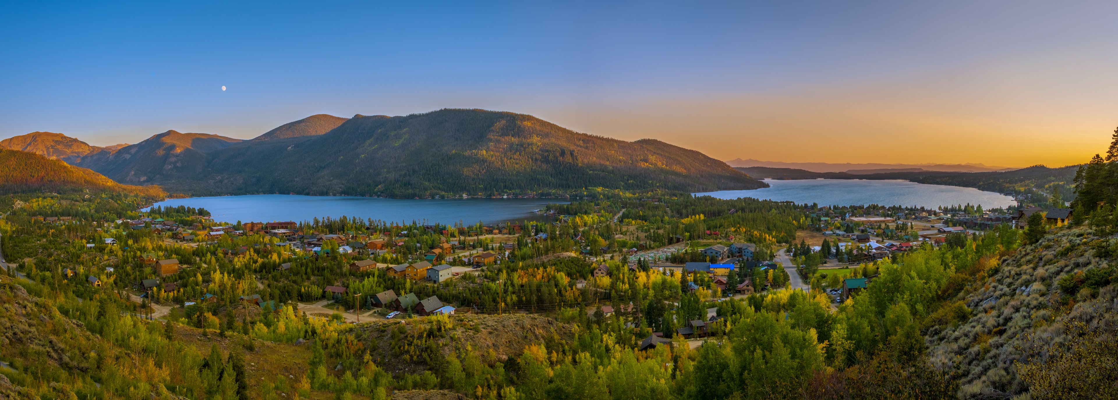 A lakeside town with mountains in the background.