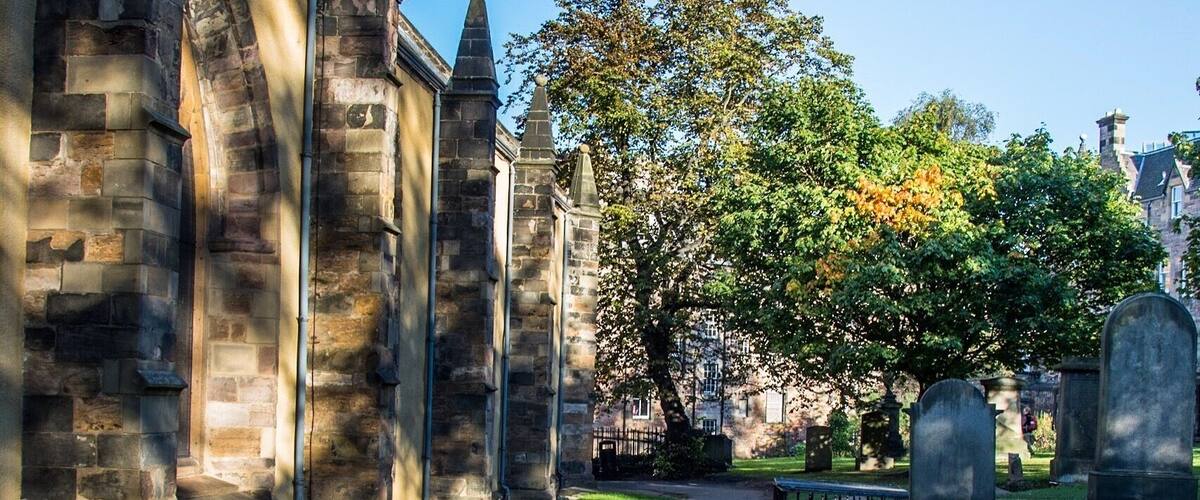 Greyfriars Kirkyard
© Paul Cunningham - Edinburgh Photo Guy
This Kirkyard is not haunted but has some history that equally is is unsettling. This place his estimated around over thousand bodies and more underneath the ground. Lots of the graves are unmarked after most of the bodies were moved from the first graveyard of Edinburgh's Old Town, St Giles behind the cathedral were moved to here.
Greyfriars takes its name from the Franciscan friary on the site (the monks of which wore grey robes), which was dissolved in 1559. The churchyard was founded in 1561, then Mary Queen of Scots made the land available for a burial ground, before then it was a herb garden to cure illnesses. St Giles burial ground was running out of room for burials.
In more recent times in history this place was rife for body snatchers, hence the mortsafe protected grave in this image.
Paul
