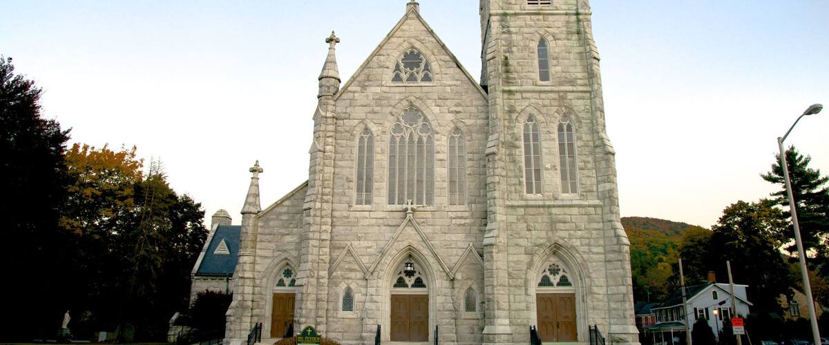 A large stone church with a tall bell tower and arched windows.