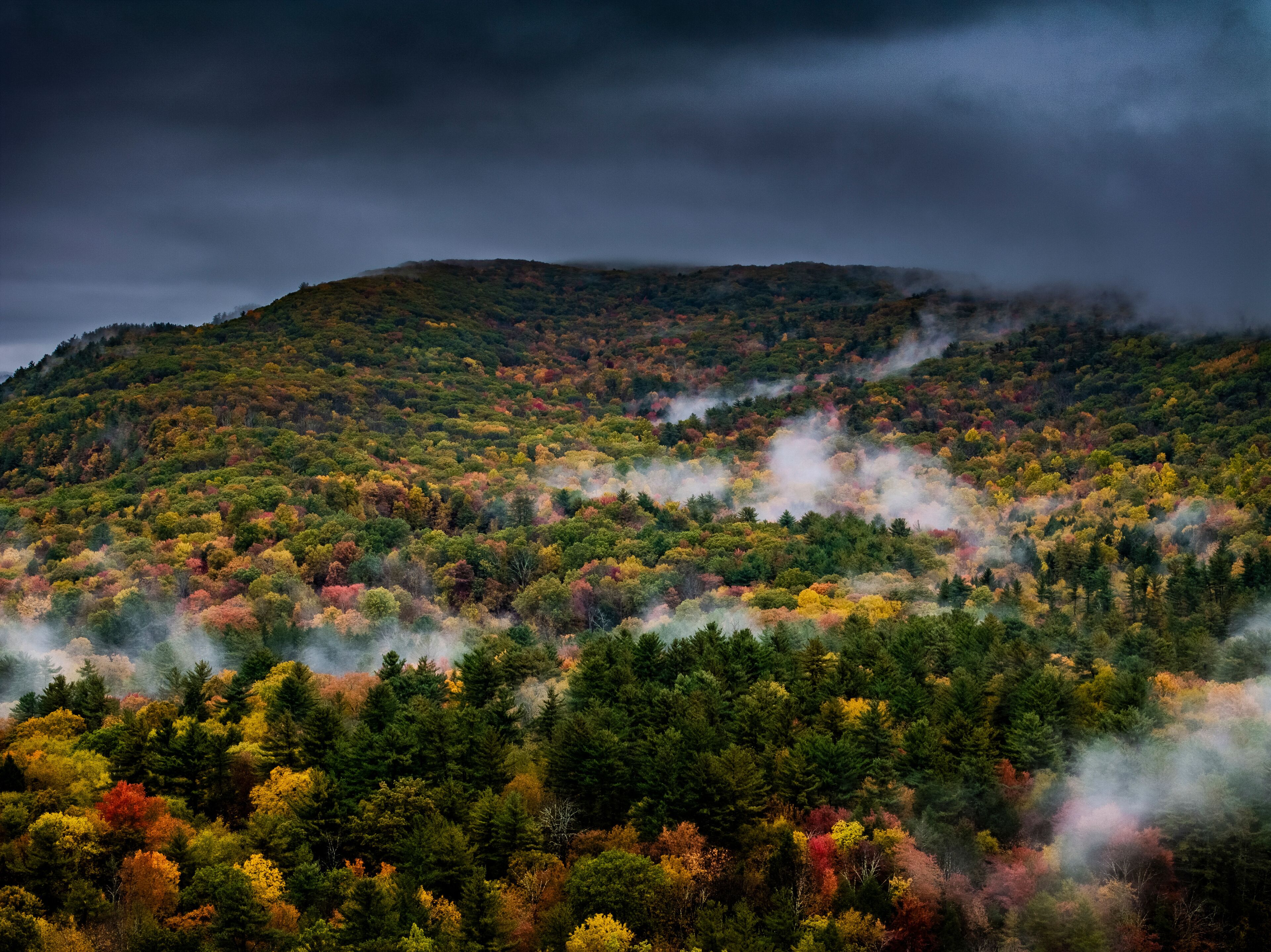 Aerial view of colorful fall foliage and misty mountains, Great Barrington, United States.