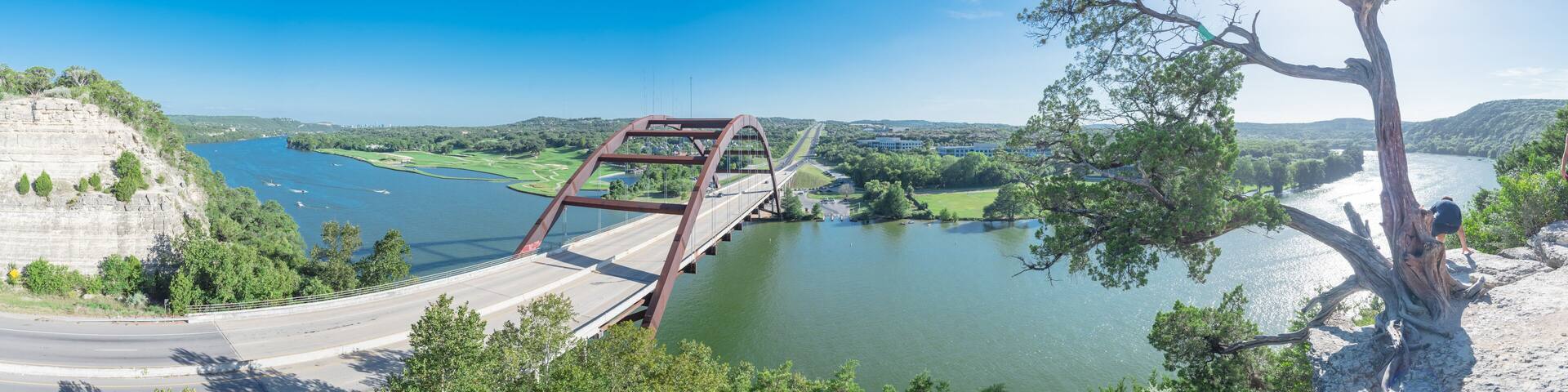 Panoramic Pennybacker Bridge over Colorado river and limestone cliff in Austin