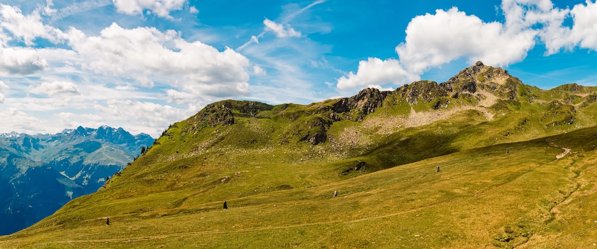 A mountain landscape with a clear sky and a distant mountain range.
