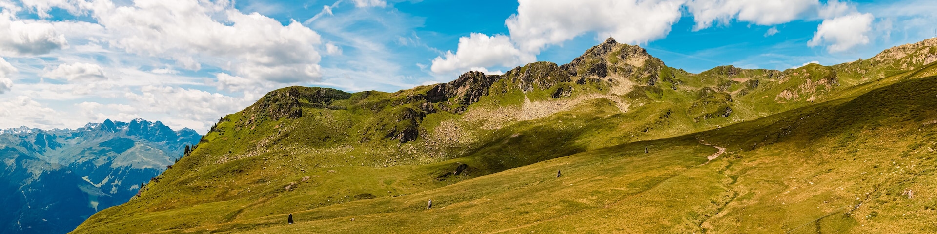 A mountain landscape with a clear sky and a distant mountain range.