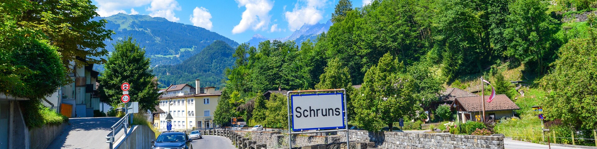 Una carretera que conduce a un pueblo de montaña con un letrero que dice 'Schruns'.