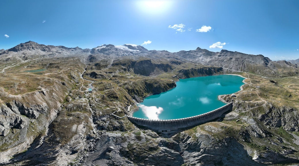 Aerial view of the Matterhorn, seen from Breuil-Cervinia. Green valleys and waterways flowing from the glaciers. Goillet reservoir and dam