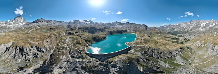 Berglandschap met een groot smaragdgroen meer en een dam.