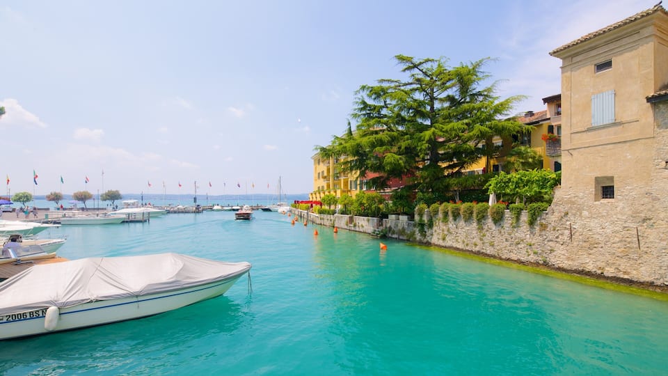A marina with boats, a stone wall, and colorful buildings.