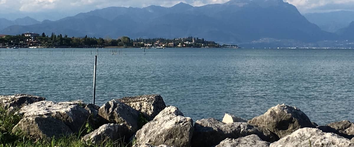 A lake with mountains in the background and a small town on the shore.