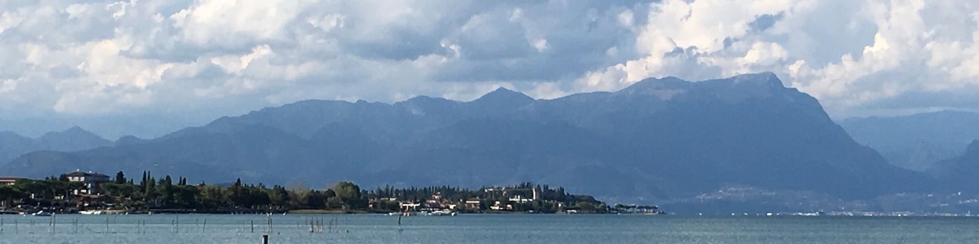 A lake with mountains in the background and a small town on the shore.