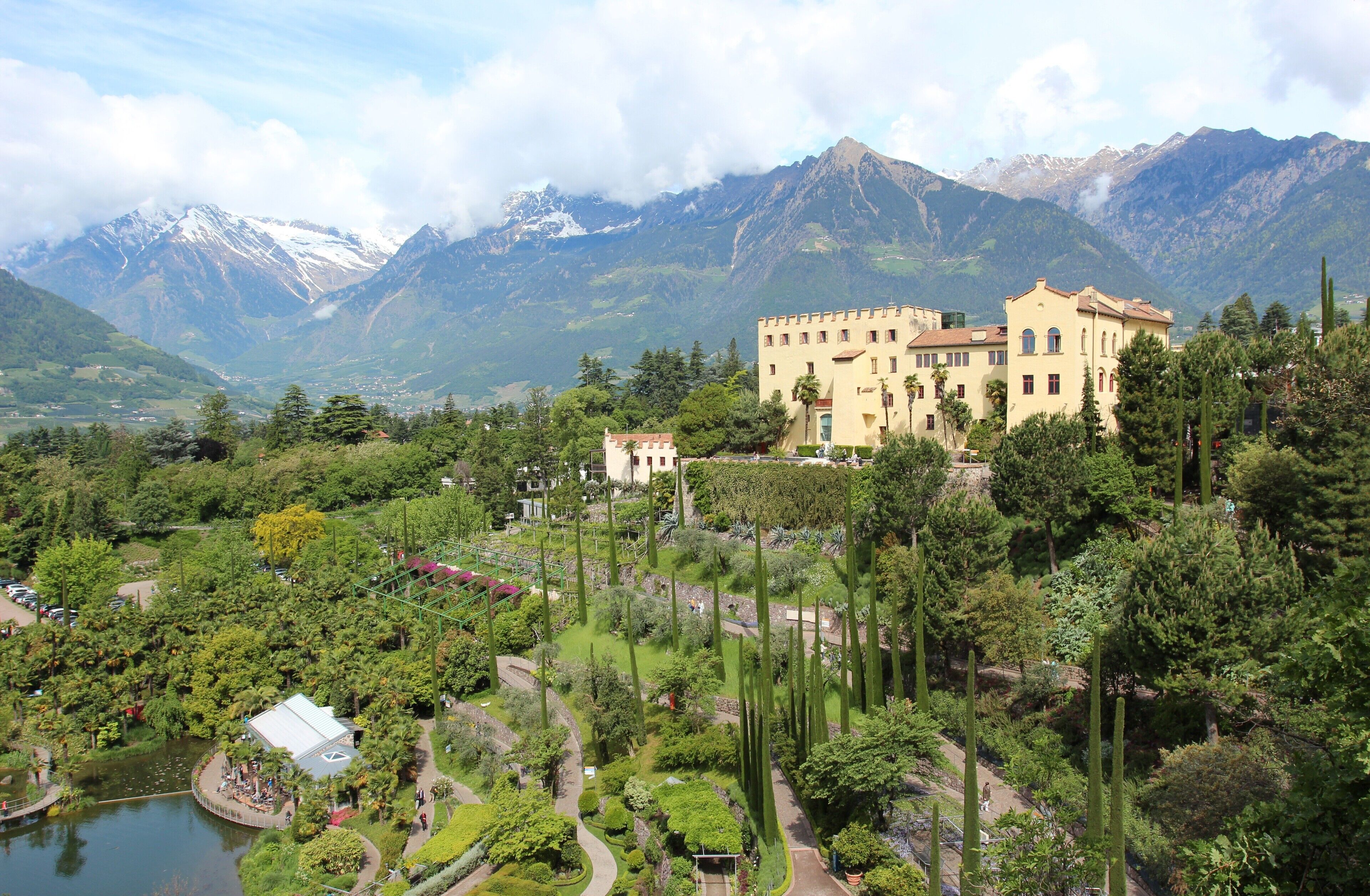 A castle surrounded by lush greenery and mountains.