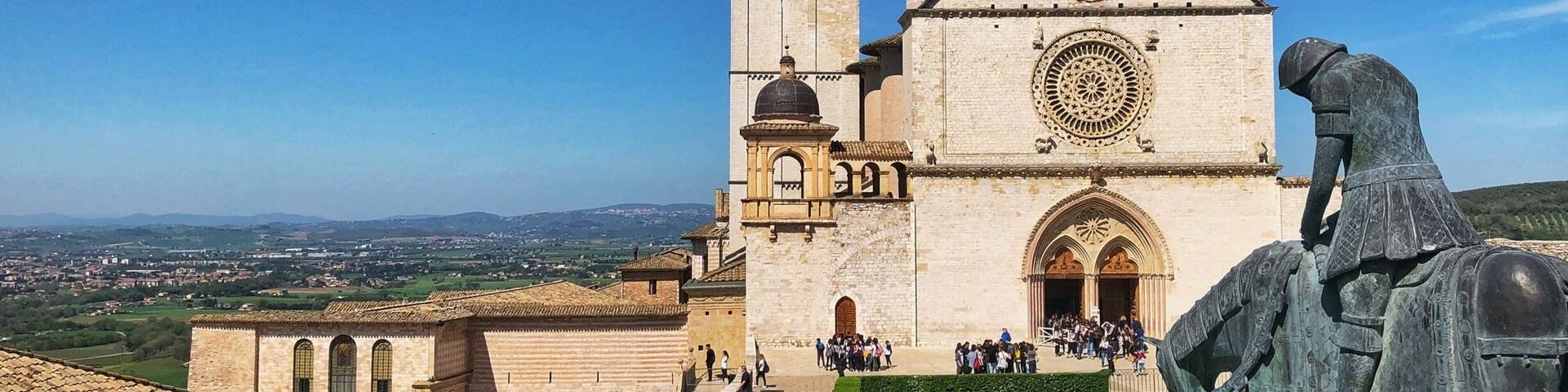 A historic church with a bell tower and a statue of a knight.