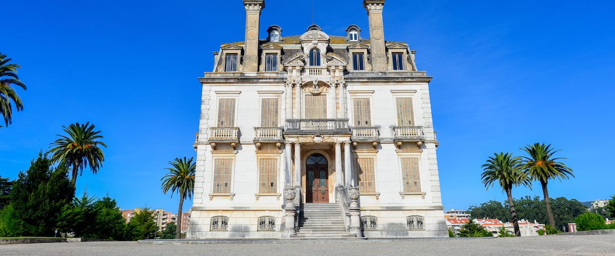 A large, ornate building with a symmetrical facade, multiple windows, and a central entrance with steps.
