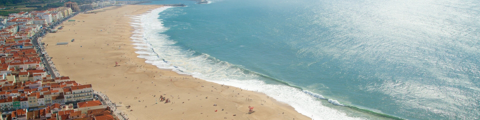 Nazare which includes general coastal views, a sandy beach and a coastal town